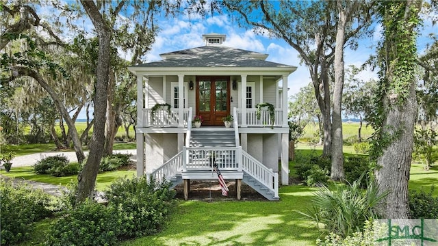 back of property featuring french doors, a porch, and a yard