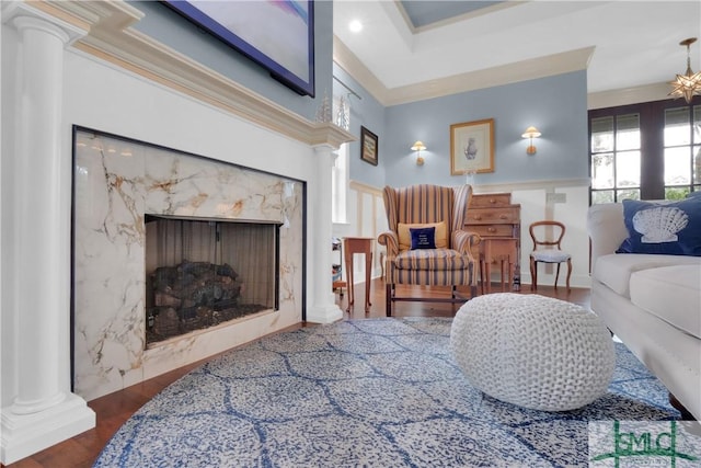 living room with decorative columns, ornamental molding, dark wood-type flooring, and a fireplace