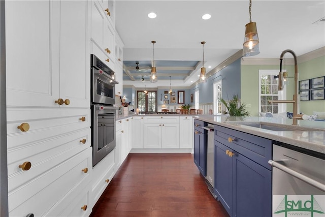 kitchen featuring decorative light fixtures, white cabinetry, stainless steel appliances, blue cabinetry, and kitchen peninsula