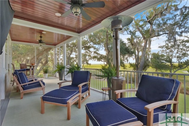 sunroom featuring ceiling fan, wooden ceiling, and a healthy amount of sunlight