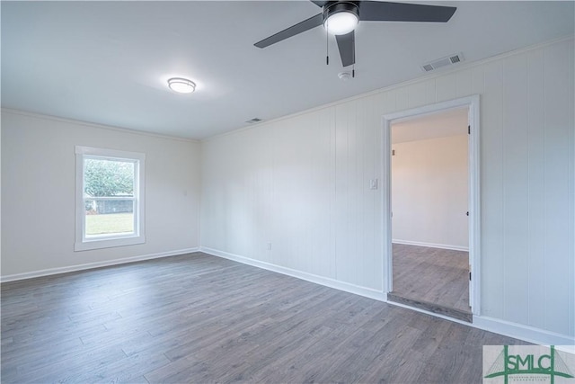 empty room with ceiling fan, crown molding, and dark hardwood / wood-style floors