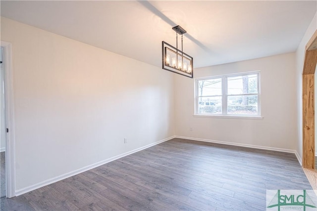 interior space featuring dark wood-type flooring and a notable chandelier