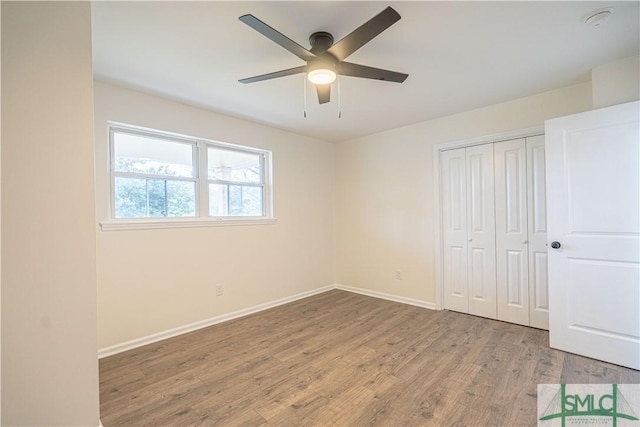 unfurnished bedroom featuring light wood-type flooring, ceiling fan, and a closet