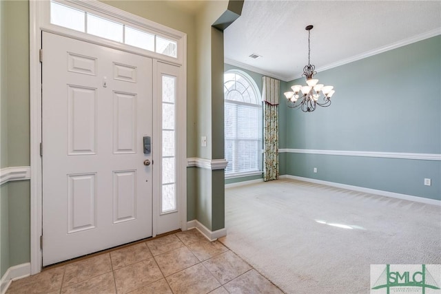 carpeted foyer entrance featuring a notable chandelier and crown molding