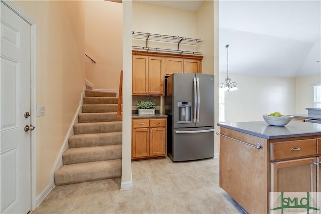 kitchen with vaulted ceiling, a chandelier, hanging light fixtures, stainless steel fridge, and backsplash