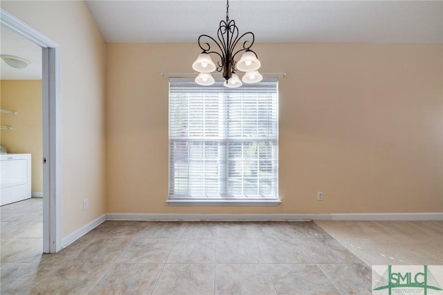 spare room with washer / clothes dryer and a chandelier