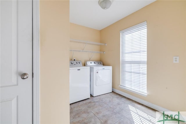 clothes washing area featuring washing machine and dryer and light tile patterned flooring