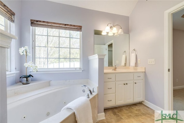 bathroom featuring vanity, a washtub, and vaulted ceiling