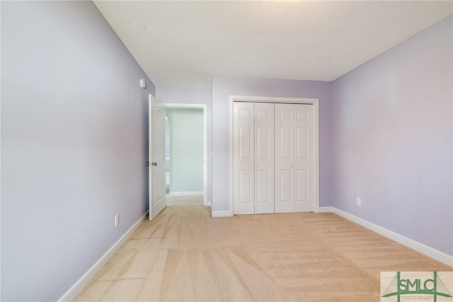 unfurnished bedroom with a textured ceiling, a closet, and light carpet