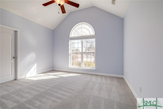 carpeted spare room with ceiling fan and vaulted ceiling