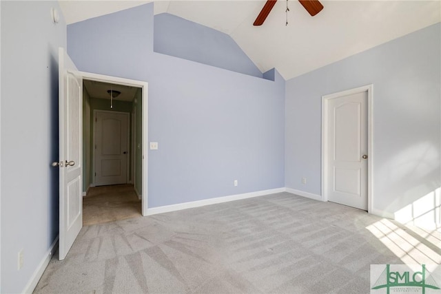 spare room with ceiling fan, vaulted ceiling, and light carpet