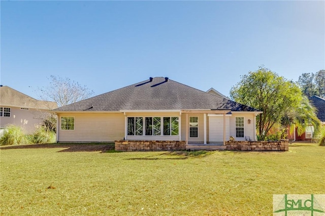 rear view of house featuring a yard