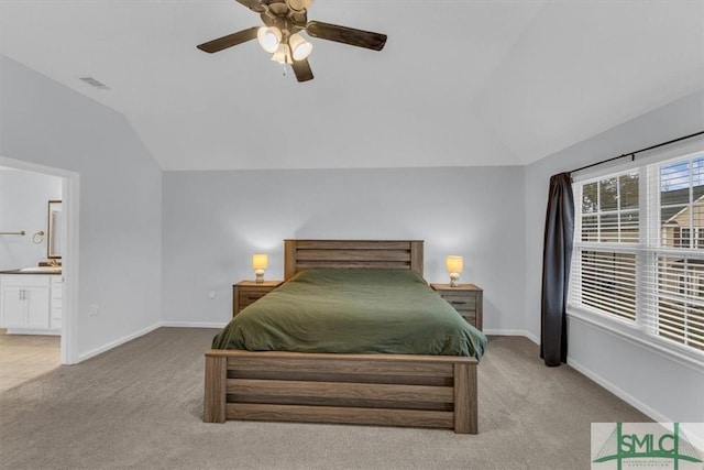 carpeted bedroom featuring lofted ceiling, ensuite bathroom, and ceiling fan