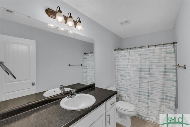 full bathroom featuring toilet, tile patterned floors, shower / bath combo with shower curtain, vanity, and a textured ceiling