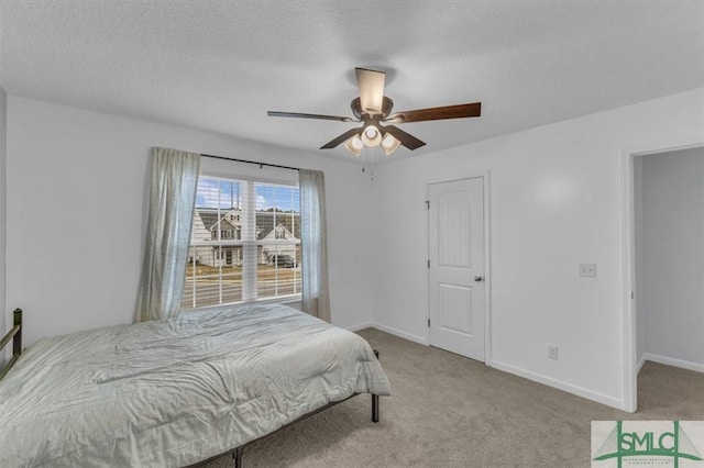 bedroom featuring a textured ceiling, ceiling fan, and light colored carpet