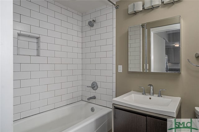 full bathroom with toilet, tiled shower / bath, and vanity