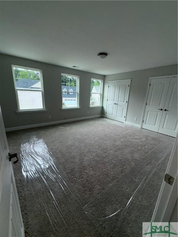 541 Sessile Oak Dr, Savannah, GA 31419 - unfurnished bedroom featuring multiple windows, carpet floors, multiple closets, and baseboards