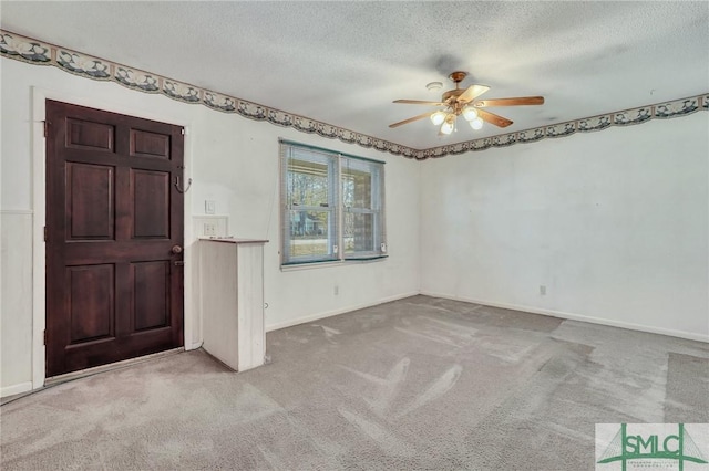 foyer featuring a textured ceiling, light colored carpet, and ceiling fan