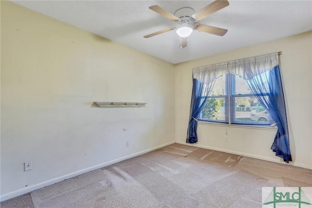 empty room featuring ceiling fan, carpet floors, and a textured ceiling