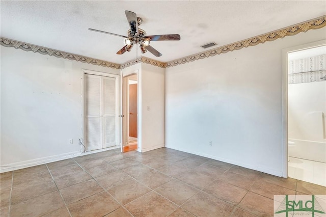 spare room featuring a textured ceiling and ceiling fan