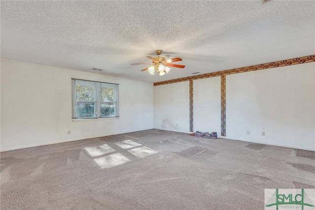 spare room with ceiling fan, light colored carpet, and a textured ceiling