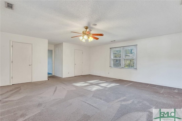 interior space with a textured ceiling, ceiling fan, and light carpet