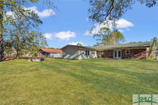 rear view of property with french doors and a yard