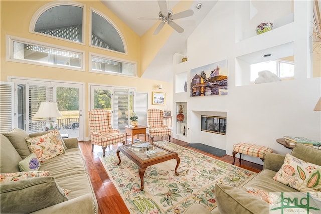 living room with dark wood-type flooring, high vaulted ceiling, and ceiling fan