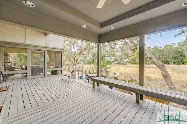 unfurnished sunroom featuring ceiling fan