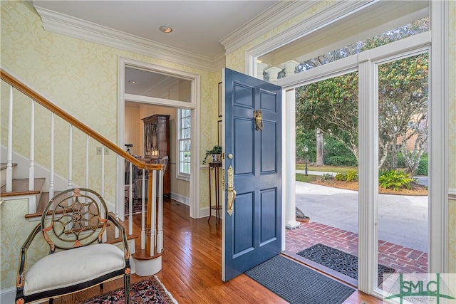 foyer entrance featuring a wealth of natural light, crown molding, and wood-type flooring