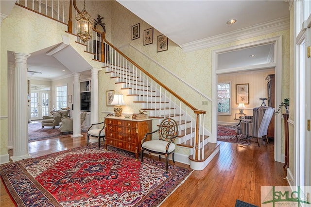 stairway featuring an inviting chandelier, french doors, crown molding, and hardwood / wood-style floors