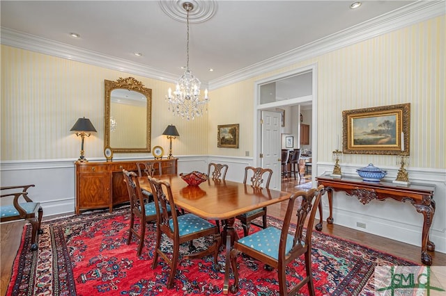 dining room featuring wood-type flooring, an inviting chandelier, and ornamental molding