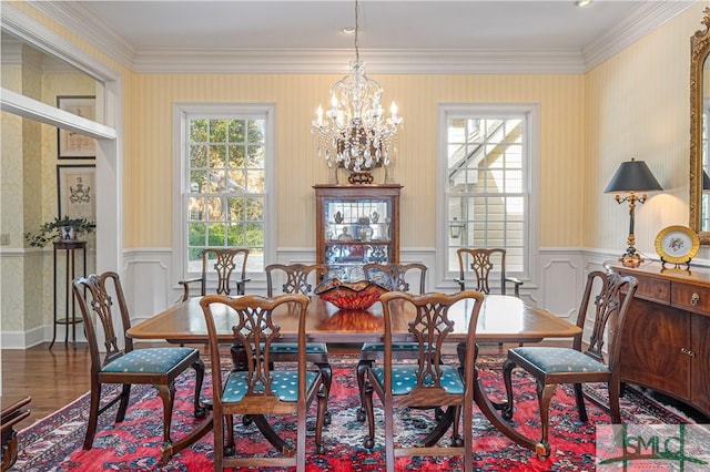 dining space with wood-type flooring, a chandelier, and ornamental molding