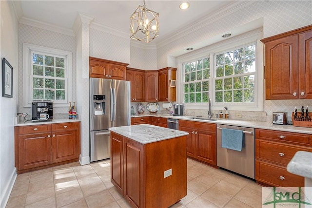 kitchen featuring pendant lighting, a notable chandelier, a kitchen island, appliances with stainless steel finishes, and sink