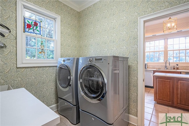 washroom with a chandelier, crown molding, light tile patterned floors, sink, and washing machine and clothes dryer