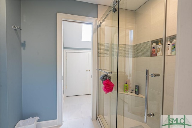 bathroom with a shower with door and tile patterned flooring