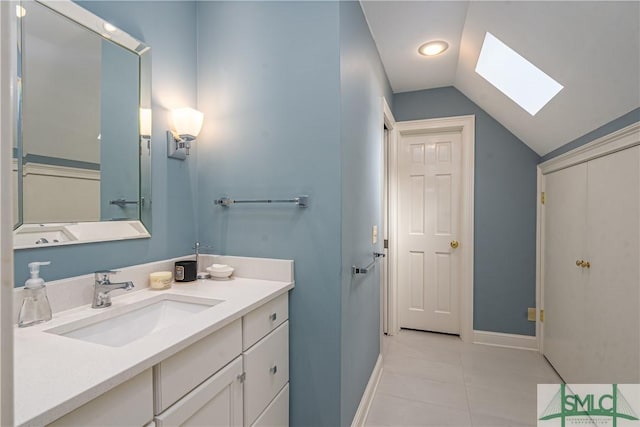 bathroom with vanity, tile patterned floors, and vaulted ceiling with skylight