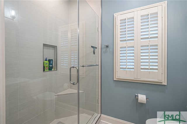 bathroom featuring toilet and a shower with door