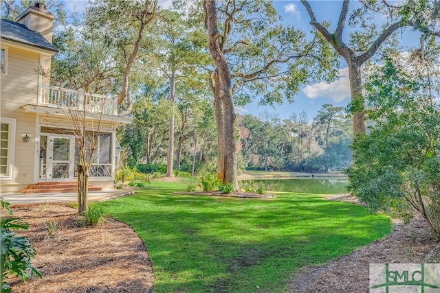 view of yard with a balcony and a water view