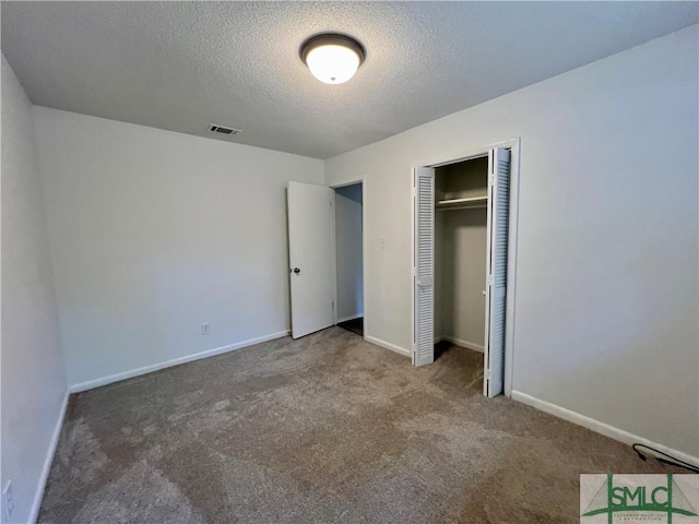 unfurnished bedroom featuring a textured ceiling, a closet, and carpet flooring