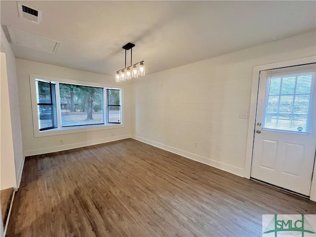 unfurnished dining area featuring hardwood / wood-style floors and a chandelier