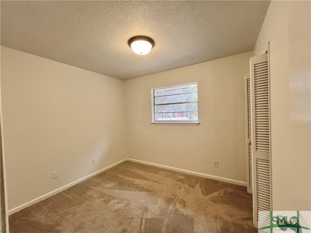 unfurnished bedroom with a textured ceiling, carpet floors, and a closet