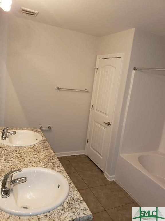 bathroom featuring a tub, tile patterned floors, and vanity