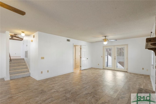 unfurnished living room with ceiling fan, french doors, and a textured ceiling