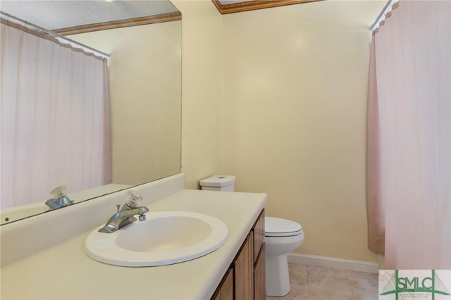 bathroom with toilet, tile patterned flooring, ornamental molding, and vanity