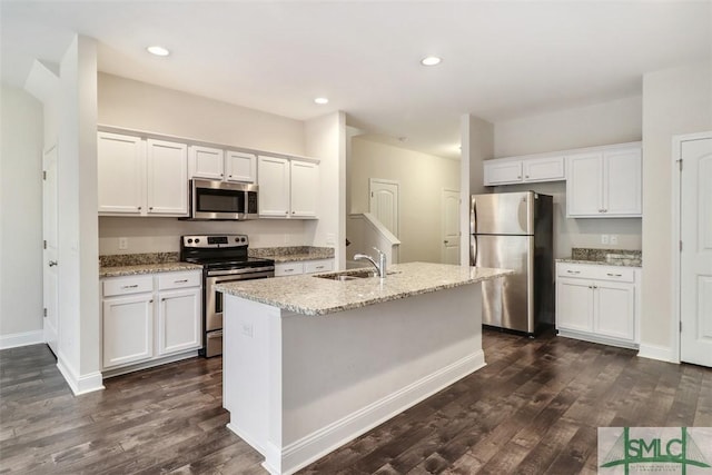 kitchen with a kitchen island with sink, stainless steel appliances, dark hardwood / wood-style flooring, sink, and white cabinetry