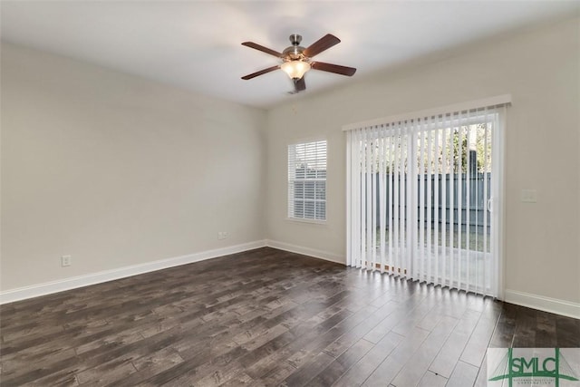 empty room with dark hardwood / wood-style flooring, ceiling fan, and a wealth of natural light