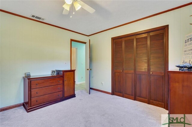 carpeted bedroom featuring ornamental molding, ceiling fan, and a closet