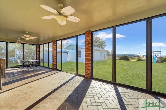 unfurnished sunroom with ceiling fan