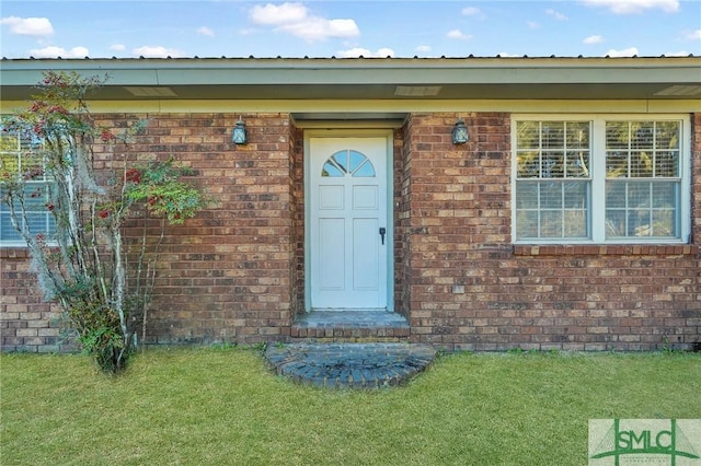 property entrance featuring a lawn